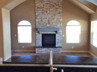 View of Living Room Fireplace from kitchen sink through custom arch interior wall