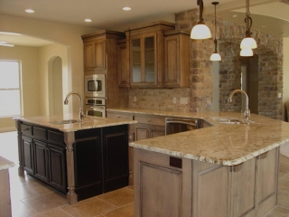 Custom Kitchen featuring custom cabinets, large bar, and rock arch